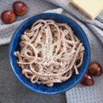 overhead view of bowl of chestnut pasta with chestnuts to side