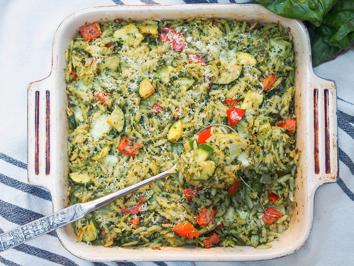 dish of creamy chard pesto baked orzo with spoonful sitting on top