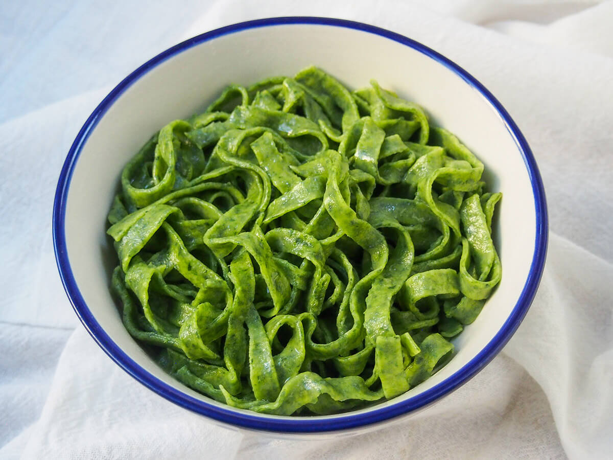 white bowl filled with fresh spinach pasta
