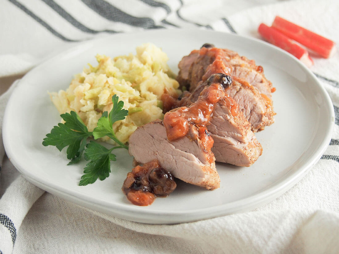 pork tenderloin with rhubarb chutney served with colcannon on white plate