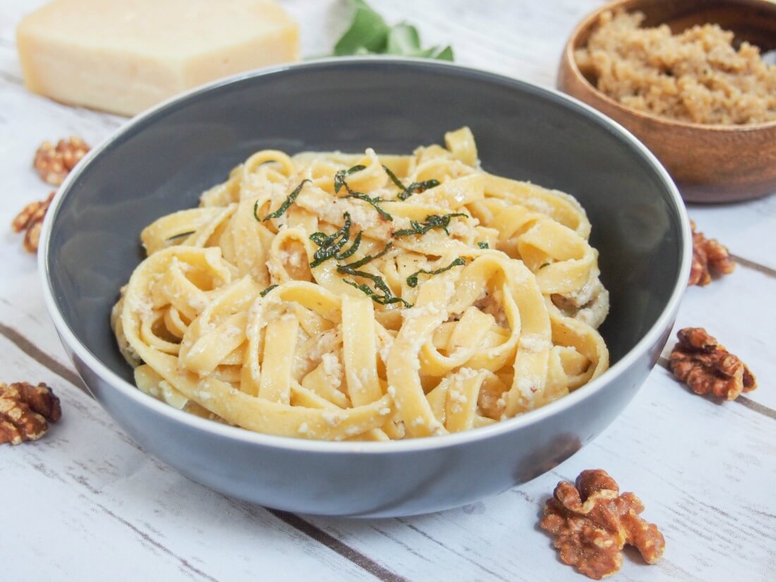 pumpkin pasta with walnut sauce mixed through and dish with additional sauce behind