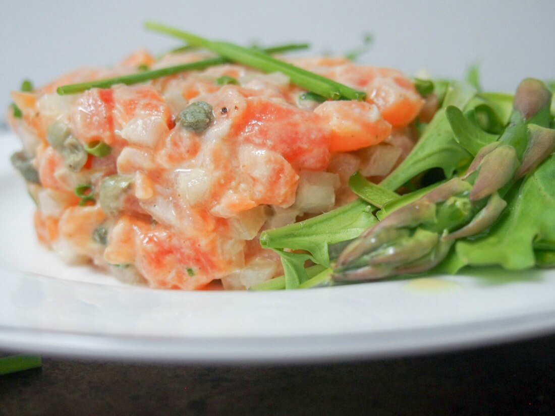 salmon tartare with salad leaves and asparagus to side