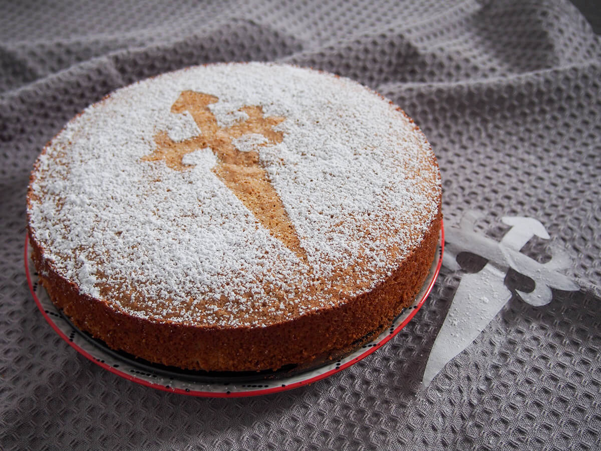 tarta de Santiago almond cake from side with stencil to side of plate
