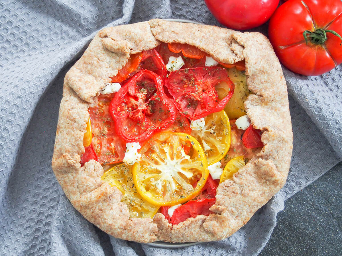 whole tomato galette with tomatoes above viewed from overhead